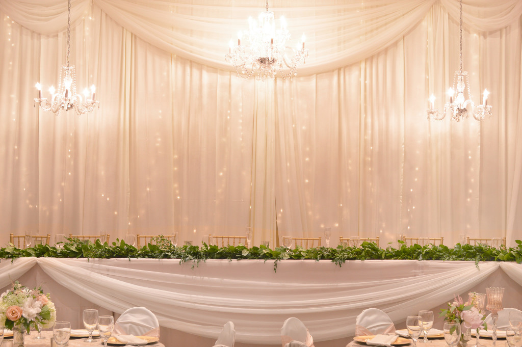 Chiffon panels are draped lengthwise on the front of this head table, then gathered at points to create swags.