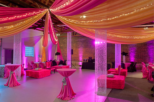 Swagged style ceiling draping in starburst pattern, featuring pink and orange chiffon panels with twinkle lights.