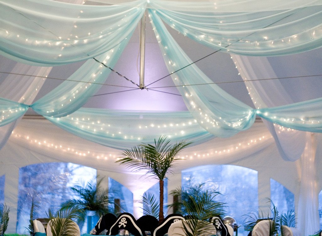 Tent draping in two layers--white chiffon along the tent ceiling up to the peak and Tiffany blue chiffon with twinkle lights at a lower level.